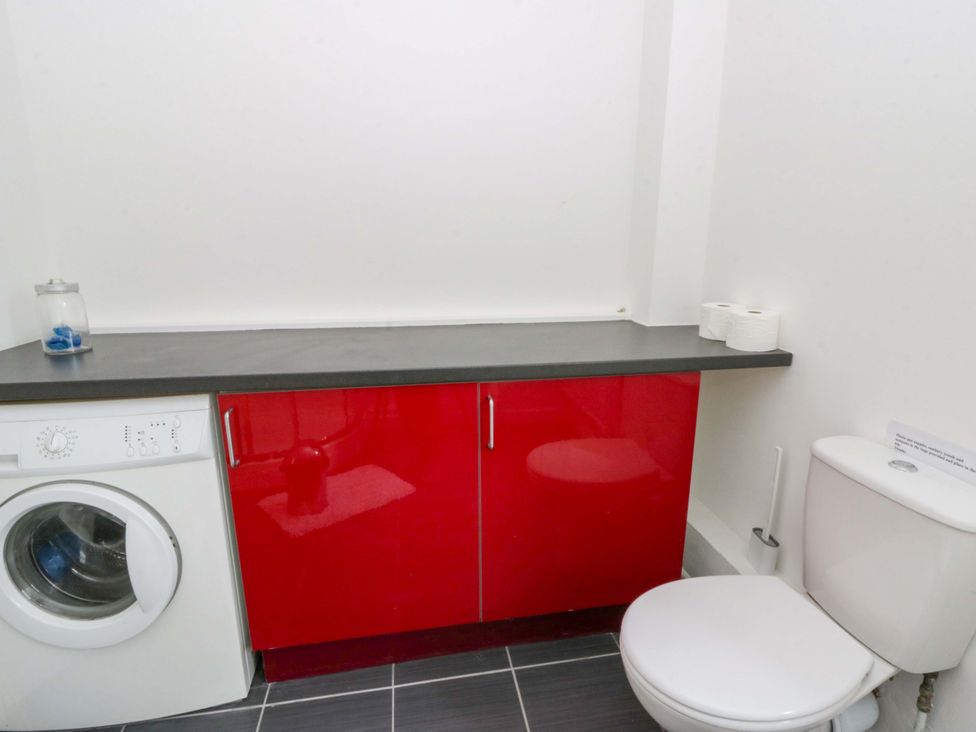 A bathroom with a washing machine and toilet at The Old Sunday School in Cwmwysg near Sennybridge