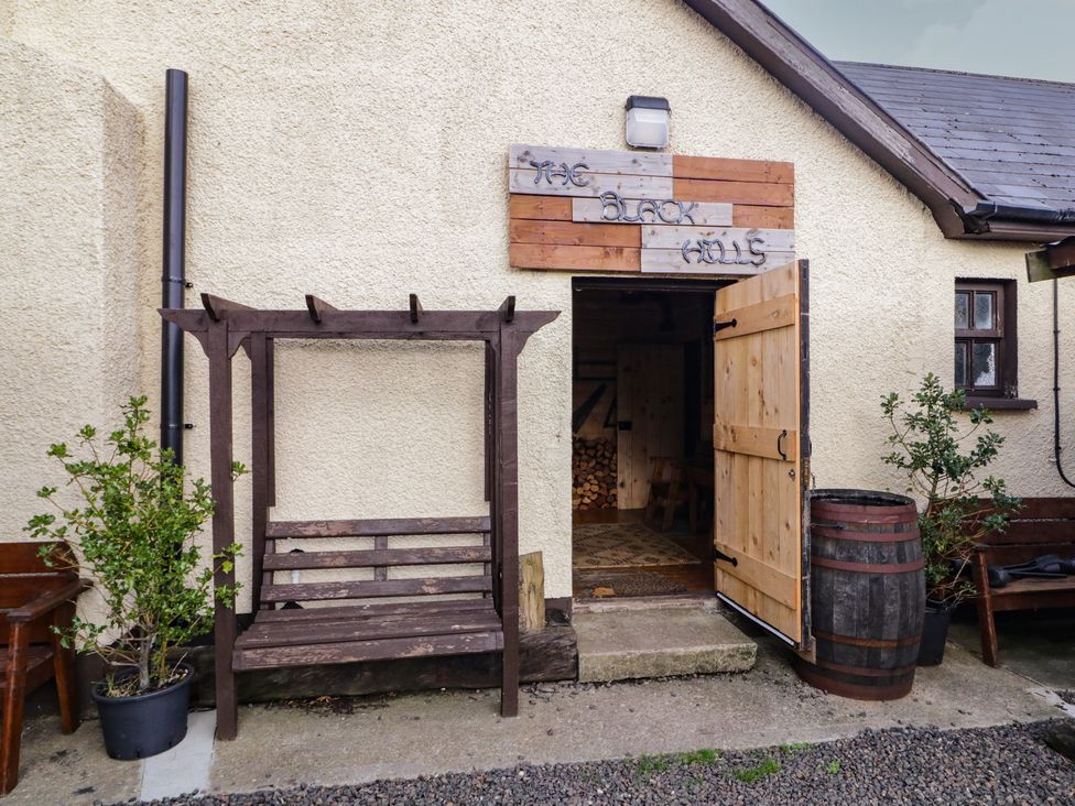 An outdoor area with a bench and barrel at The Black Halls in Limavady