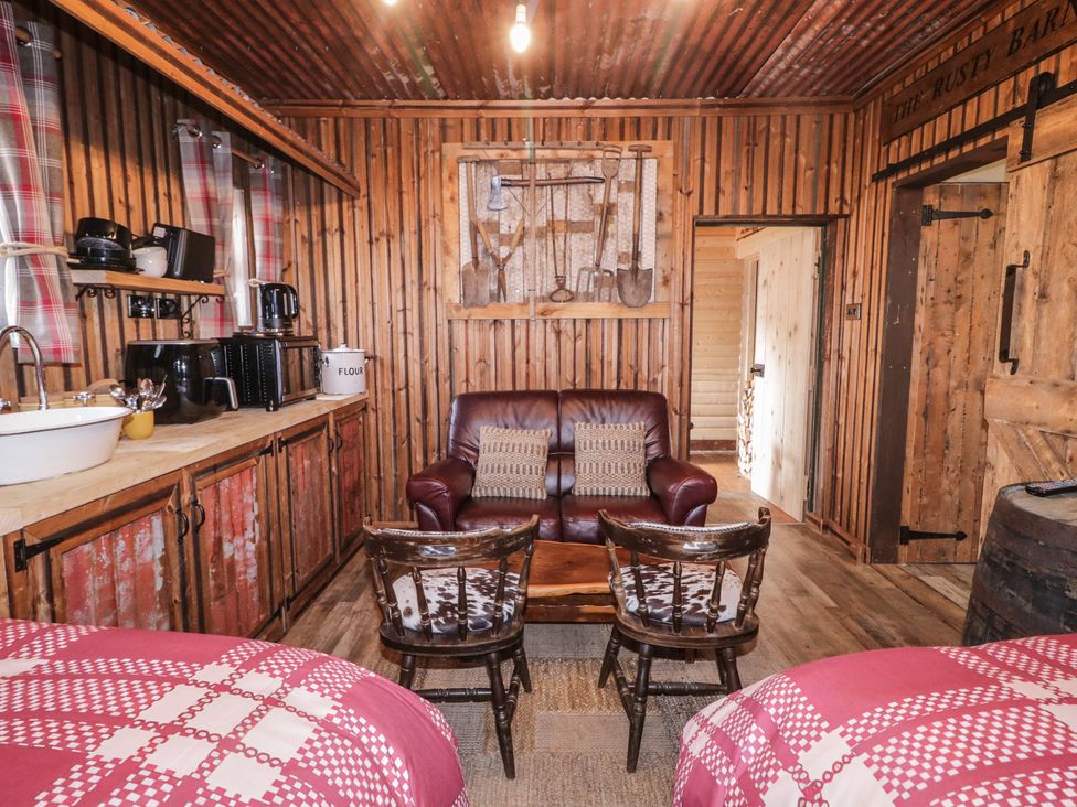 A living room with a sofa and chairs at Rusty Barn in Limavady