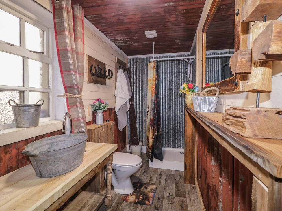 A bathroom with a bathtub and toilet at Rusty Barn in Limavady