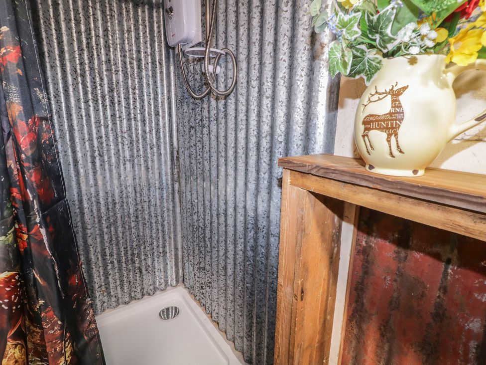 A bathroom with a shower and decorative items at Rusty Barn in Limavady