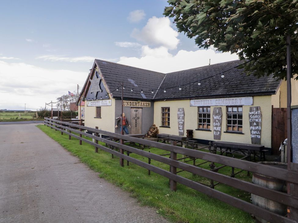A building with signs and tables outside at Rusty Barn in Limavady