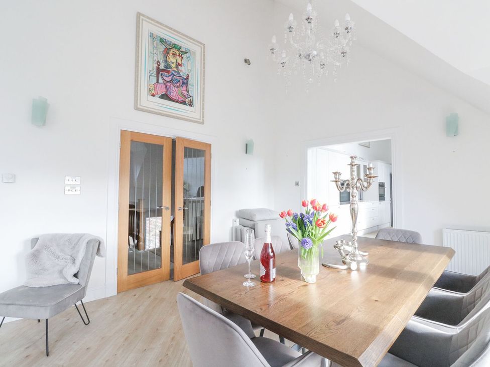 A dining room with a table and flowers at Macgregor Ranch Achnabobane near Spean Bridge