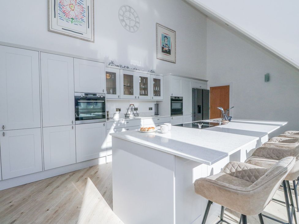 A kitchen with an island and stools at Macgregor Ranch Achnabobane near Spean Bridge