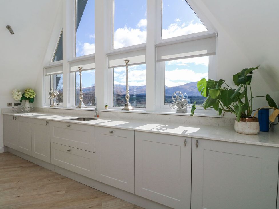 A kitchen with cabinets and a sink at Macgregor Ranch in Achnabobane near Spean Bridge