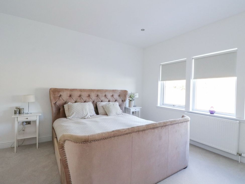A bedroom with a bed and bedside table at Macgregor Ranch Achnabobane near Spean Bridge