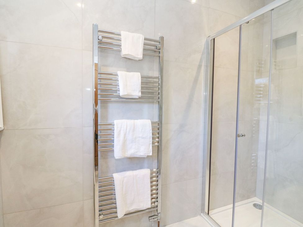 A bathroom with a towel rail and a glass shower door at Macgregor Ranch Achnabobane near Spean Bridge