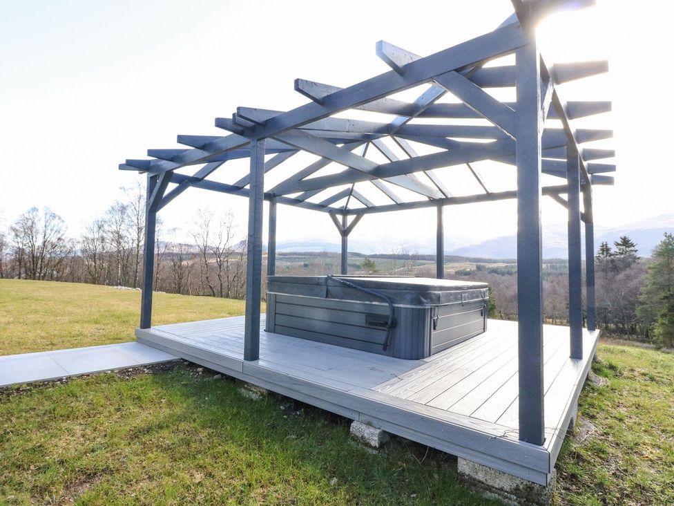An outdoor area with a hot tub under a pergola at Macgregor Ranch Achnabobane near Spean Bridge