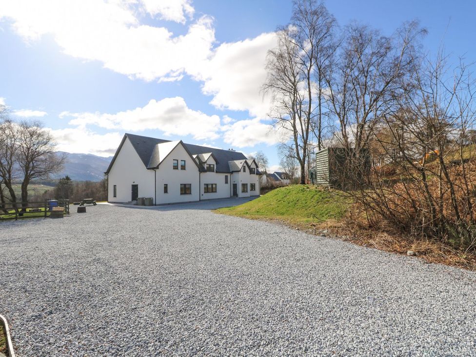 A house with a gravel driveway and trees at Macgregor Ranch in Achnabobane near Spean Bridge
