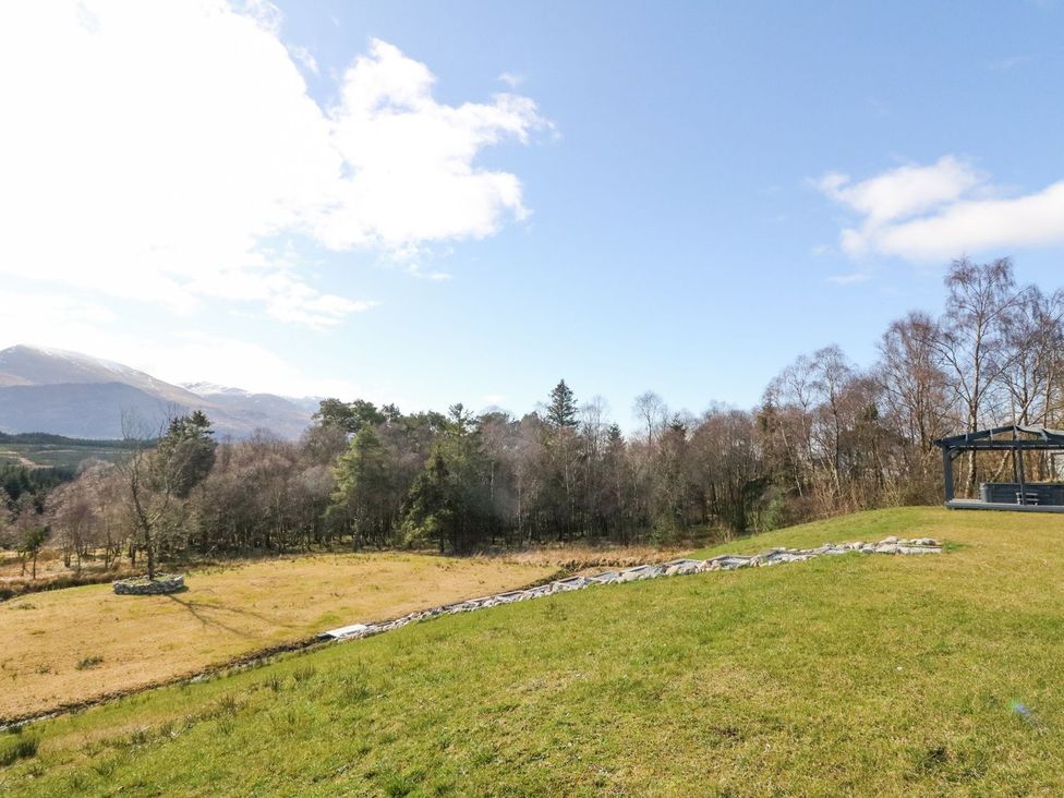 An outdoor space with grass and trees at Macgregor Ranch in Achnabobane near Spean Bridge