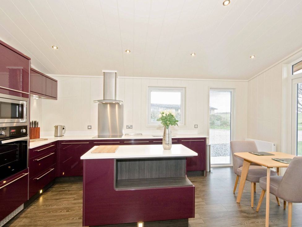 A kitchen with cooking appliances and a dining area at Brayton in Aspatria