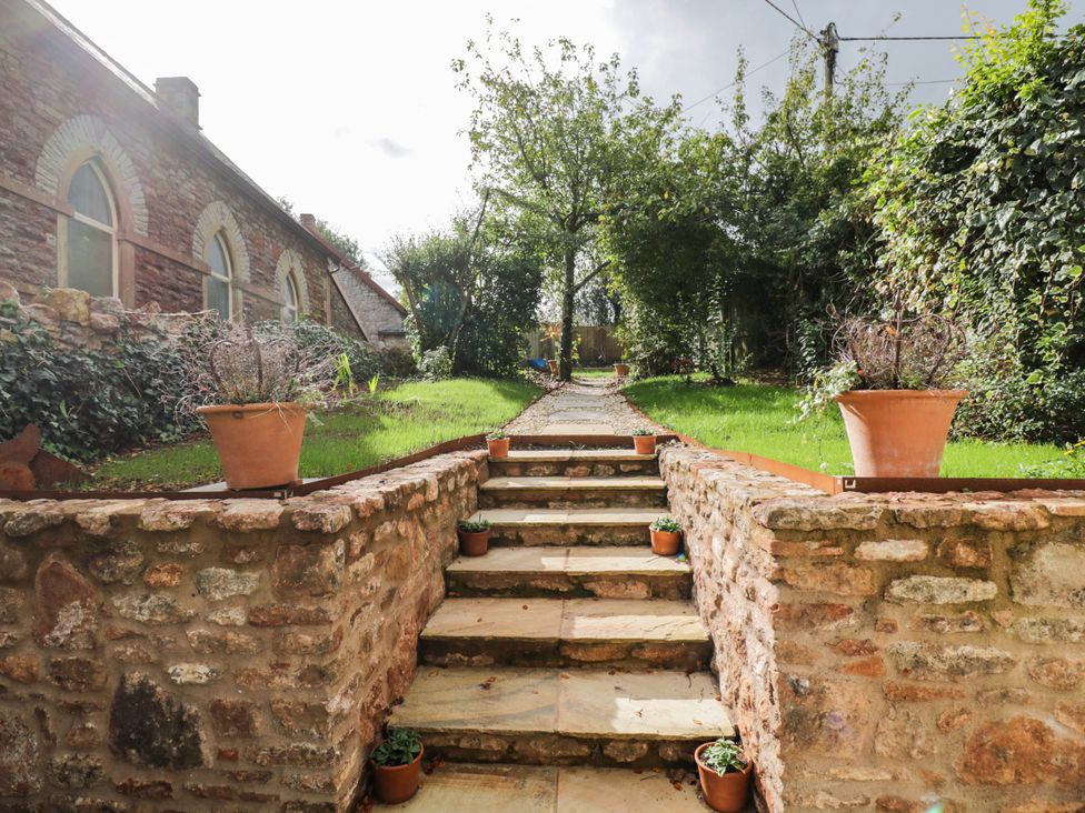 A garden with stone steps and potted plants at Redwood Cottage in Bristol