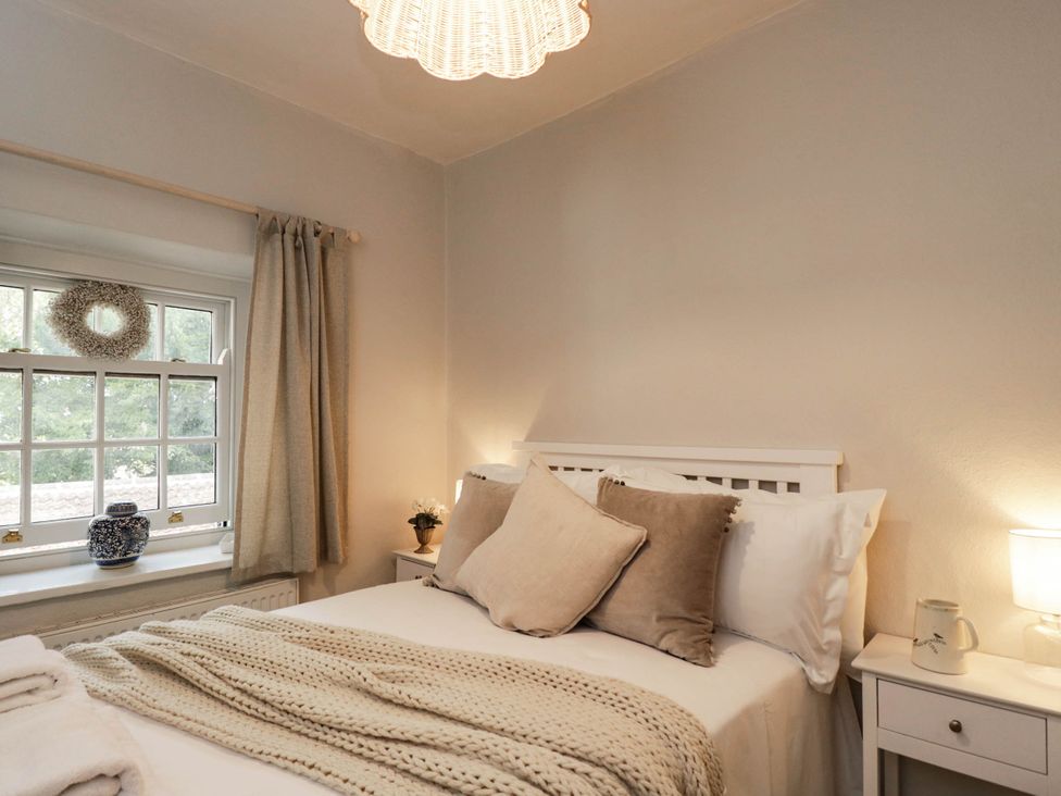 A bedroom with a bed and window at Redwood Cottage in Bristol