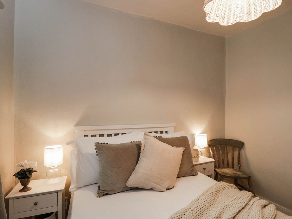 A bedroom with a bed and side table at Redwood Cottage in Bristol