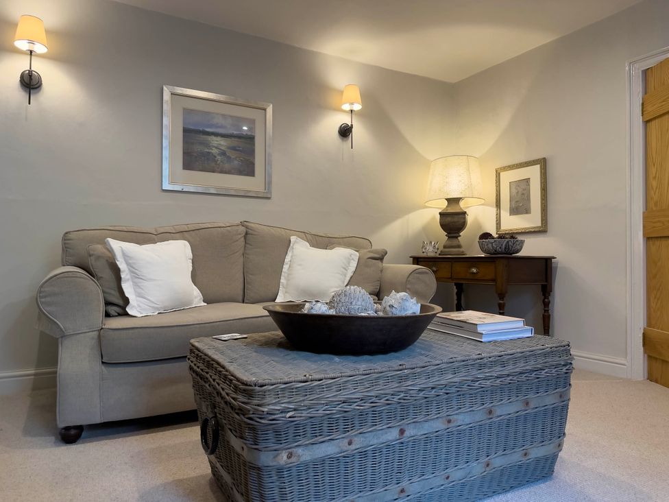 A living room with a sofa and a table at Redwood Cottage in Blagdon