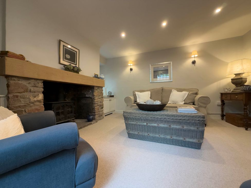 A living room with a fireplace and sofa at Redwood Cottage in Blagdon