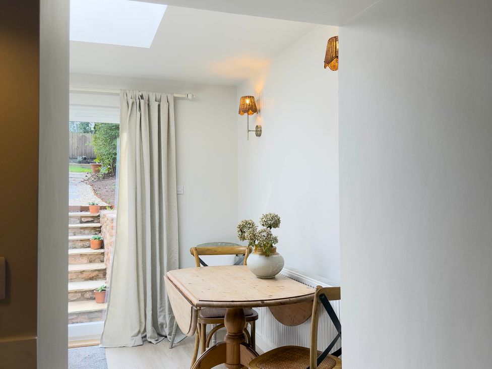 A dining room with a table and chairs at Redwood Cottage in Blagdon