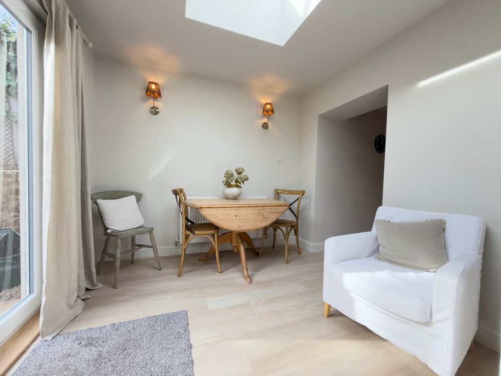 A dining room with a wooden table and chairs at Redwood Cottage in Blagdon