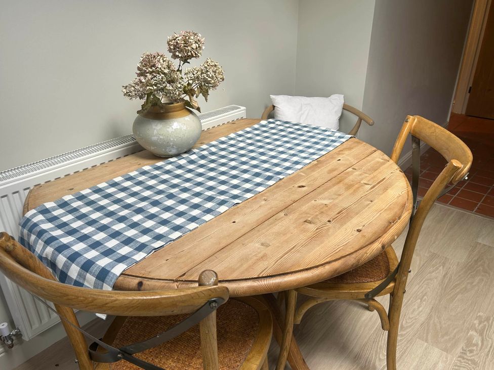 A table with a vase of flowers at Redwood Cottage in Blagdon