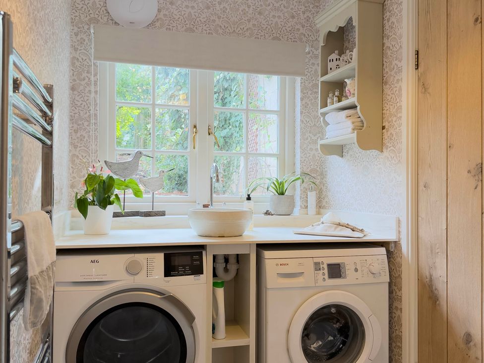 A laundry room with a washing machine and sink at Redwood Cottage in Blagdon