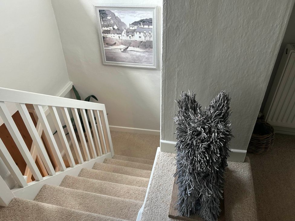 A staircase with a painting and a decorative figure at Redwood Cottage in Blagdon