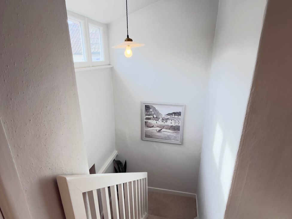 A staircase with a light fixture and windows at Redwood Cottage in Blagdon