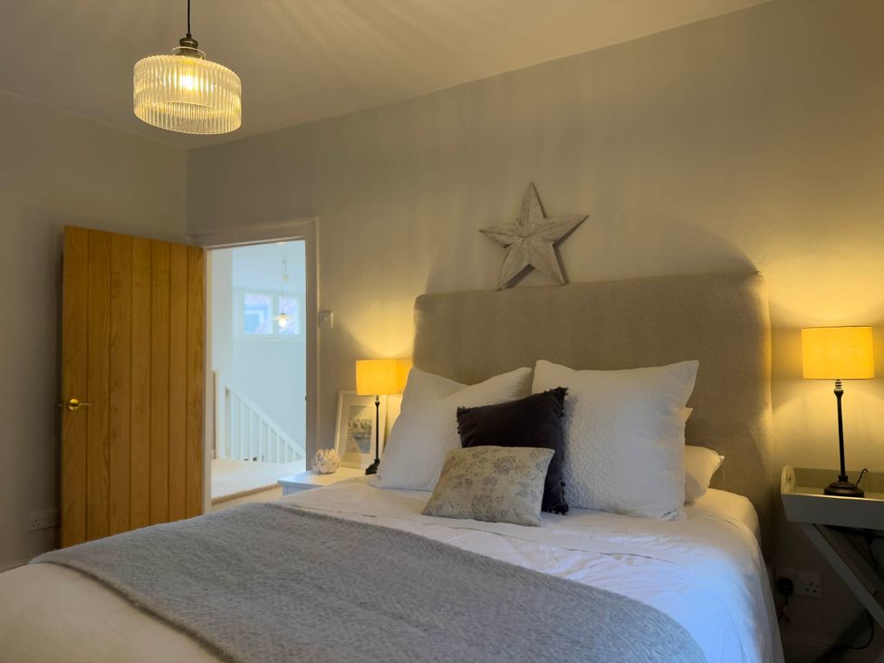 A bedroom with a bed and lamps at Redwood Cottage in Blagdon