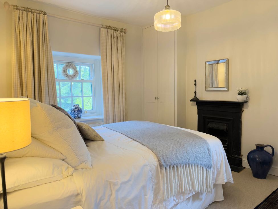 A bedroom with a bed and lamp at Redwood Cottage in Blagdon