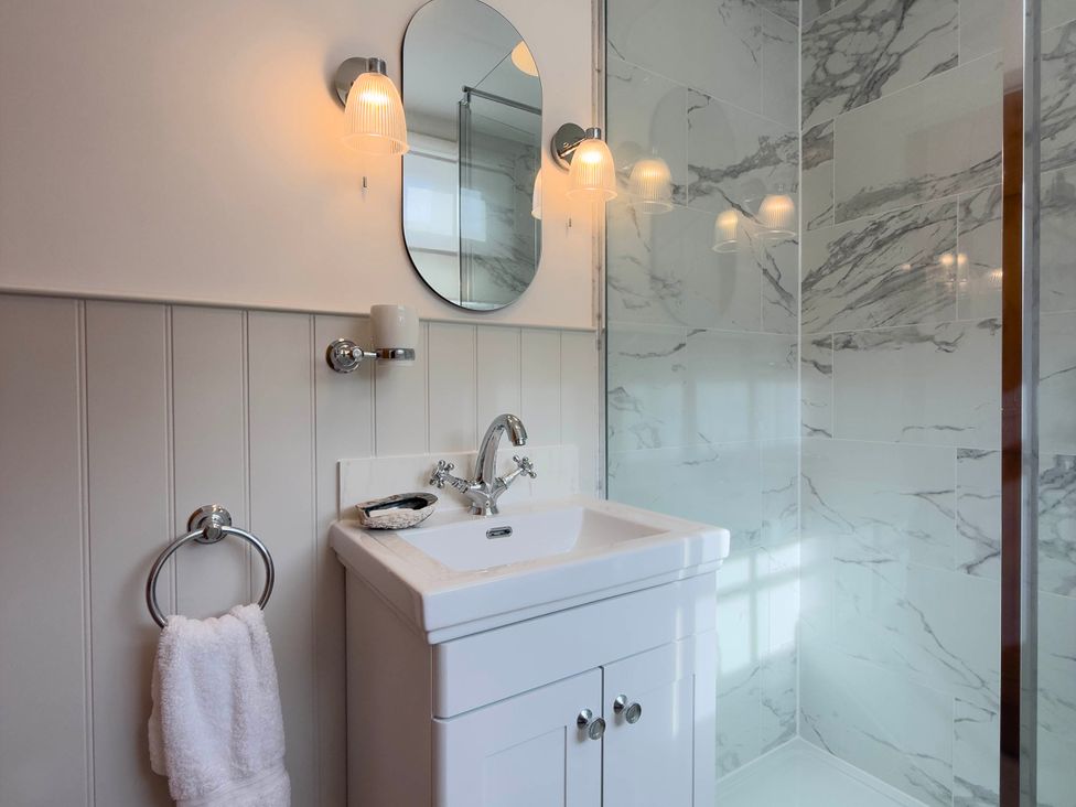 A bathroom with a sink and mirror at Redwood Cottage in Blagdon
