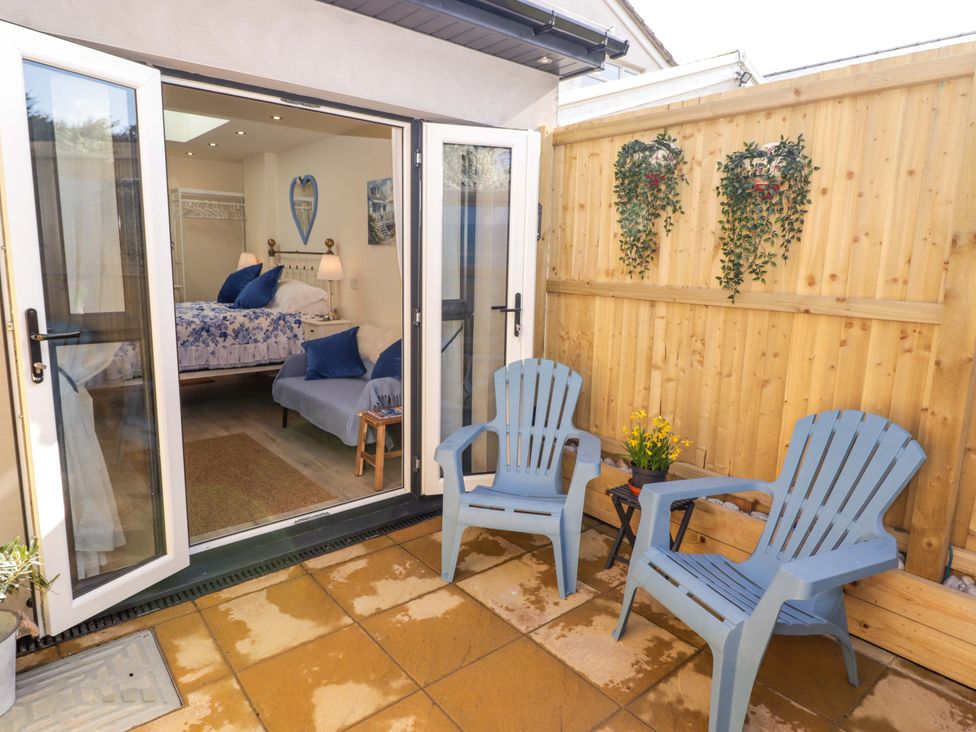 An outdoor seating area with blue chairs and a table at Sea Folly