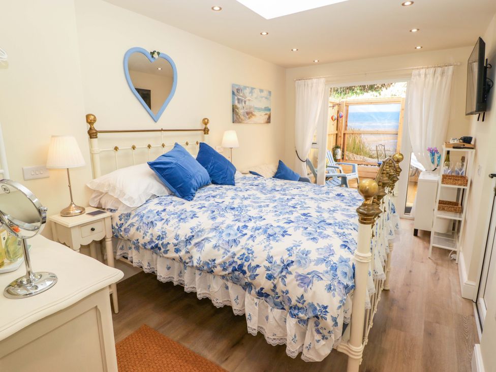 A bedroom with a double bed and a door leading outside at Sea Folly