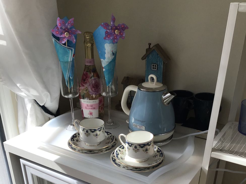 A tea set with cups, a kettle and sparkling wine at Sea Folly in Porthcawl