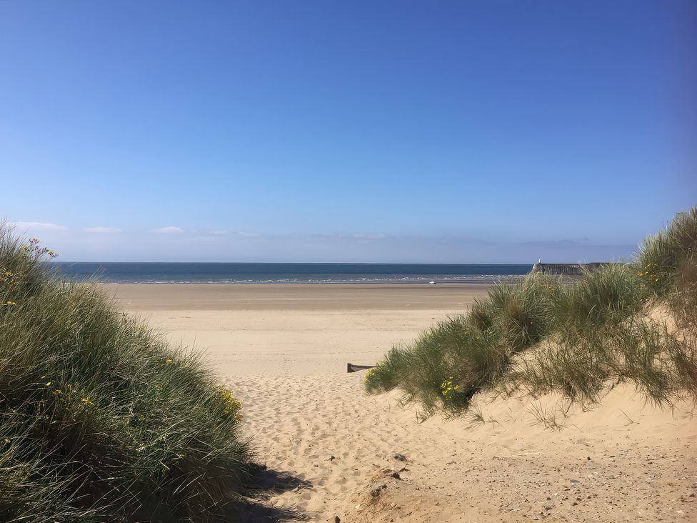 A beach scene with sand dunes and ocean view at Sea Folly in Porthcawl