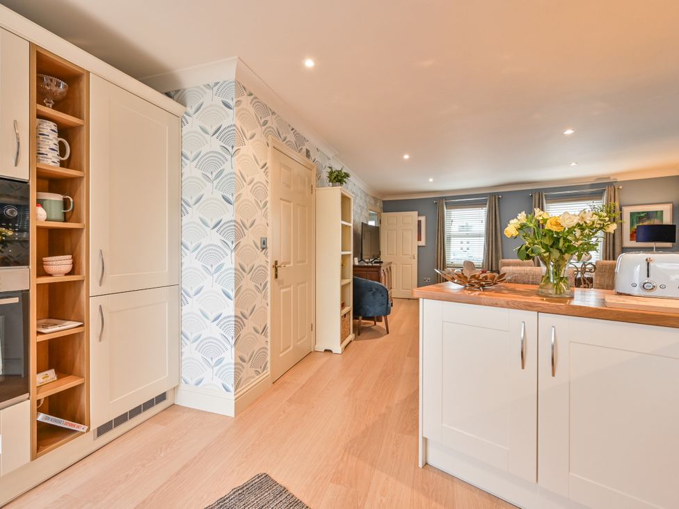 A kitchen with cabinets and a door at Lisburne Place in Torquay