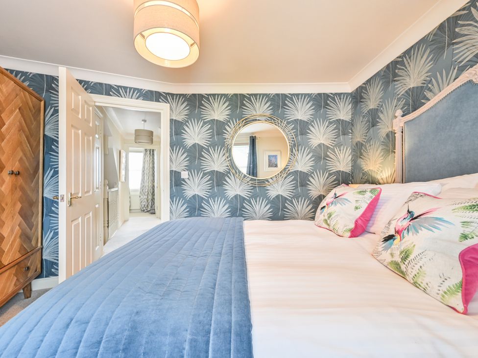 A bedroom with a bed and wardrobe at Lisburne Place in Torquay