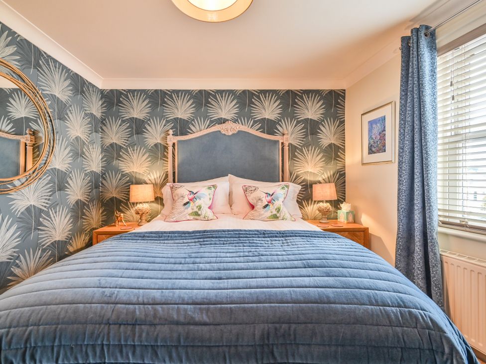 A bedroom with a bed and bedside tables at Lisburne Place in Torquay