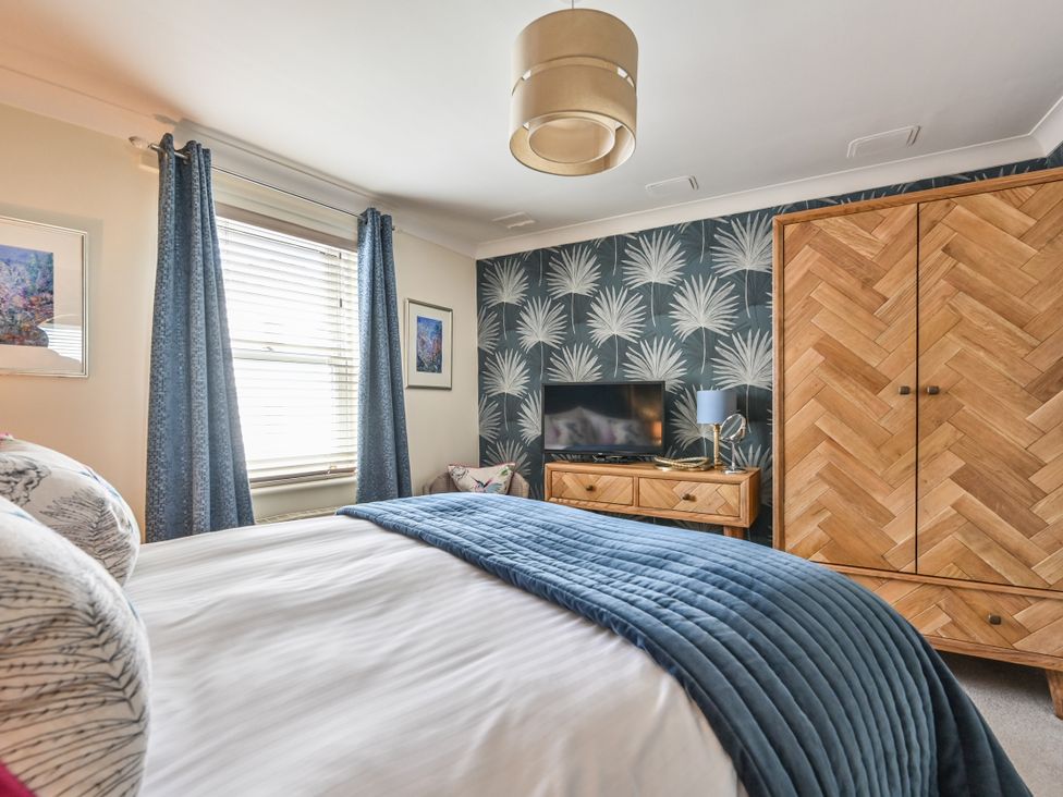 A bedroom with a bed and wardrobe at Lisburne Place in Torquay
