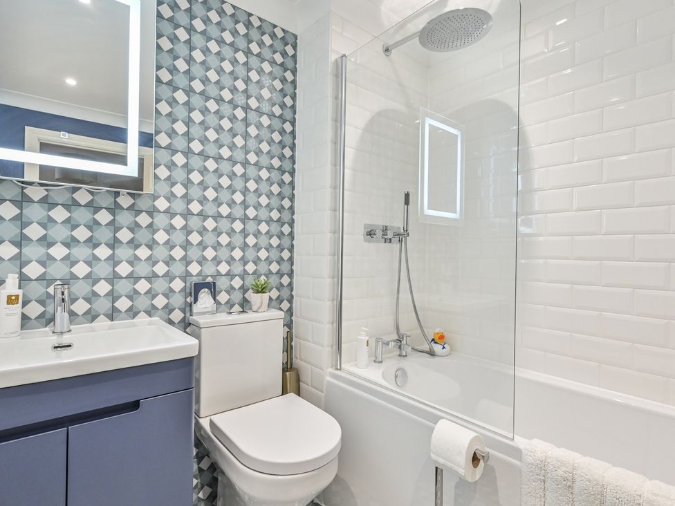 A bathroom with a shower tub and sink at Lisburne Place in Torquay