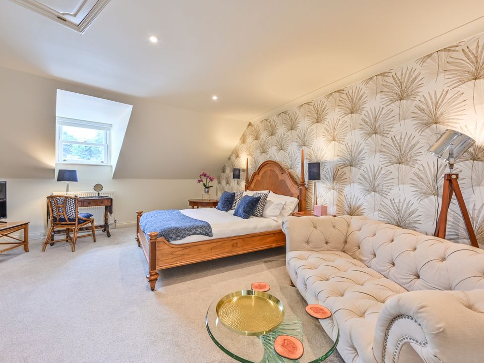 A bedroom with a bed and sofa at Lisburne Place in Torquay