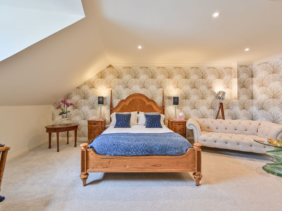 A bedroom with a bed and a sofa at Lisburne Place in Torquay