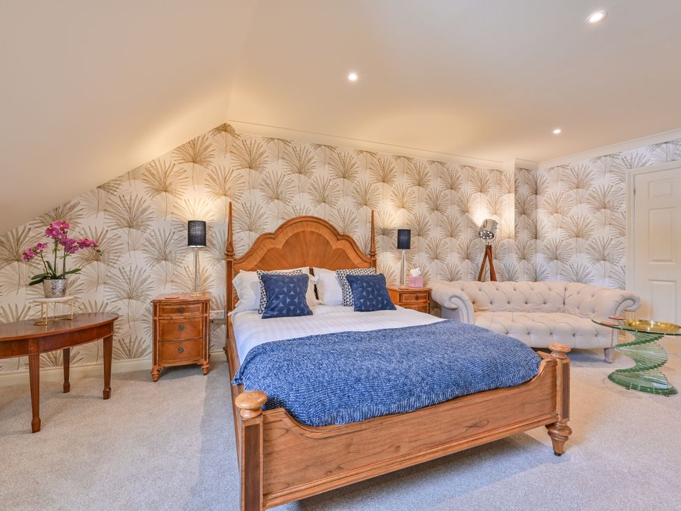 A bedroom with a bed and a sofa at Lisburne Place in Torquay