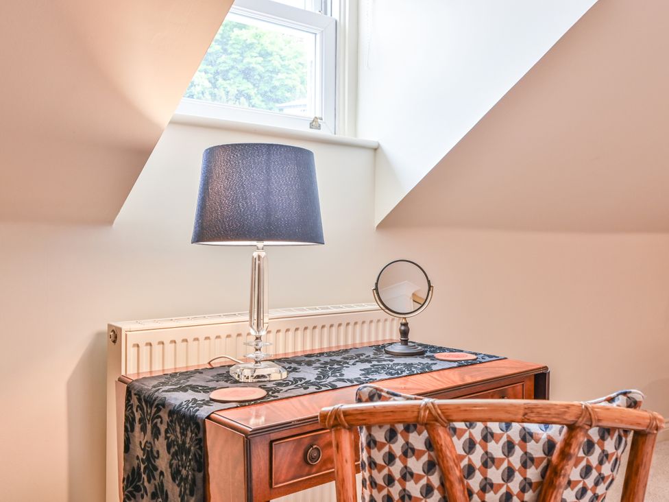 A desk with a lamp and mirror at Lisburne Place in Torquay
