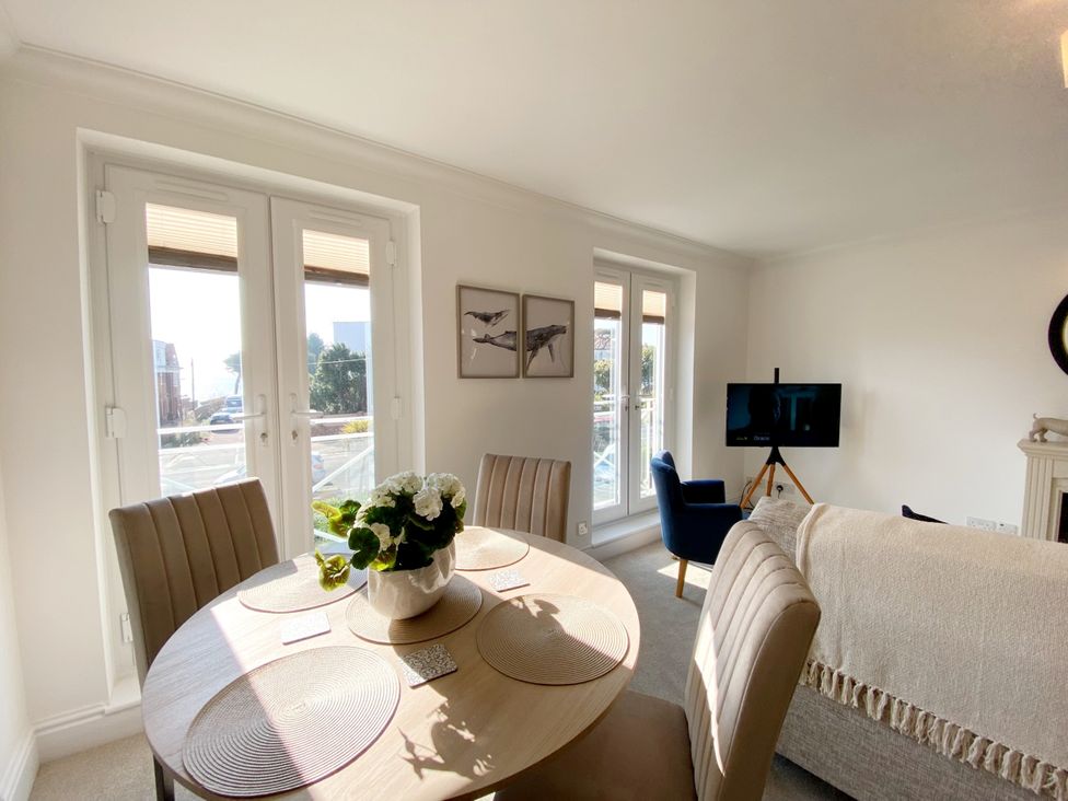 A dining room with a table and chairs at The Degas Sea View Suite in Torquay