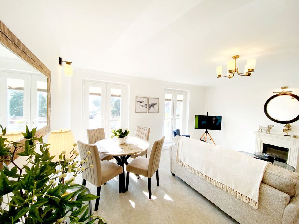 A living room with a table and chairs at The Degas Sea View Suite in Torquay