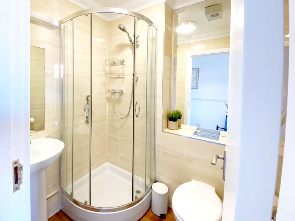 A bathroom with a shower, sink, and toilet at The Degas Sea View Suite Torquay