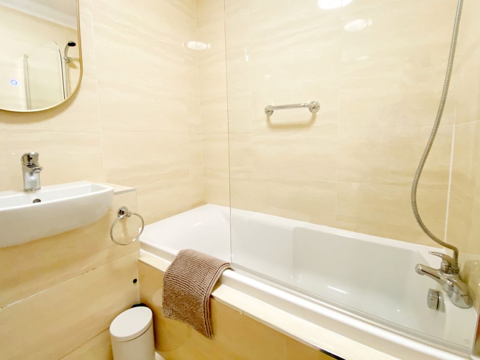 A bathroom with a bathtub and wash basin at The Degas Sea View Suite Torquay