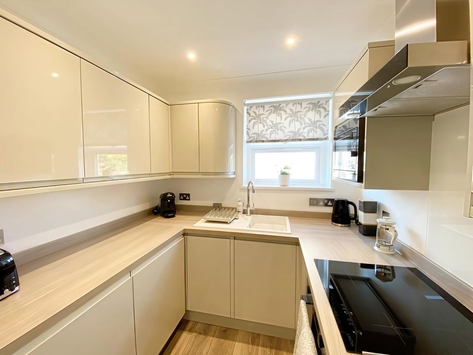A kitchen with cabinets, sink and appliances at The Degas Sea View Suite in Torquay