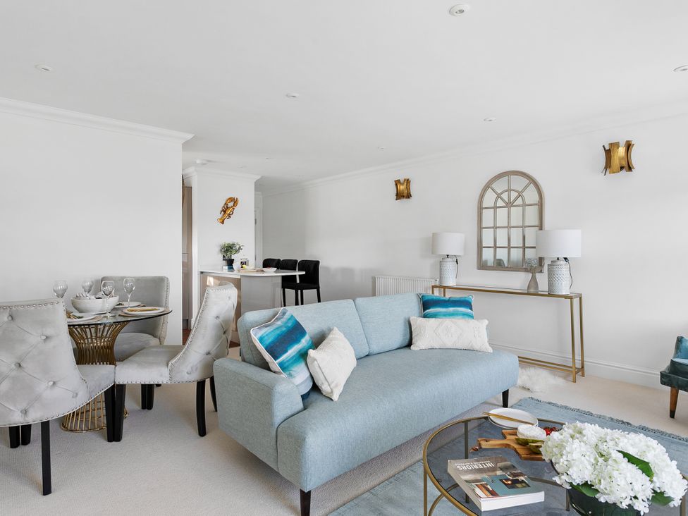 A living room with a sofa and dining area at The Renior Sea View Suite in Torquay