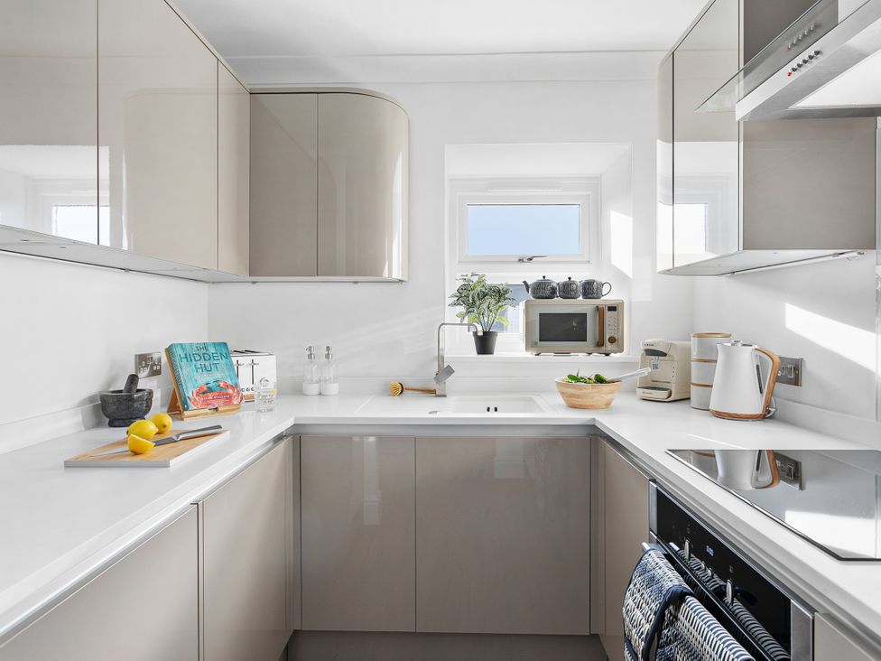 A kitchen with cabinets and countertop at The Renior Sea View Suite in Torquay