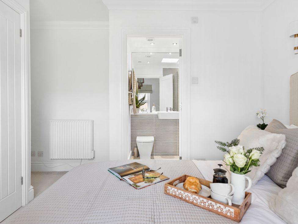 A bedroom containing a bed and a connected bathroom at The Renior Sea View Suite in Torquay